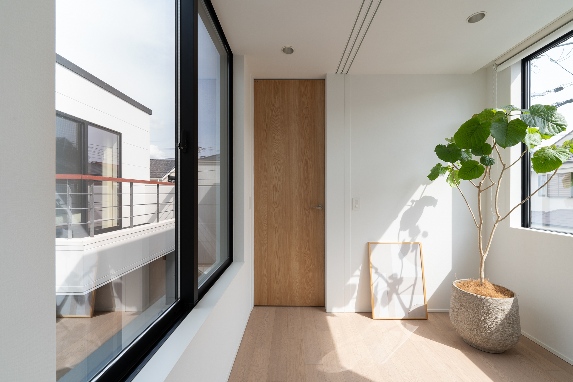 両側の窓から光が入る住宅の広い廊下