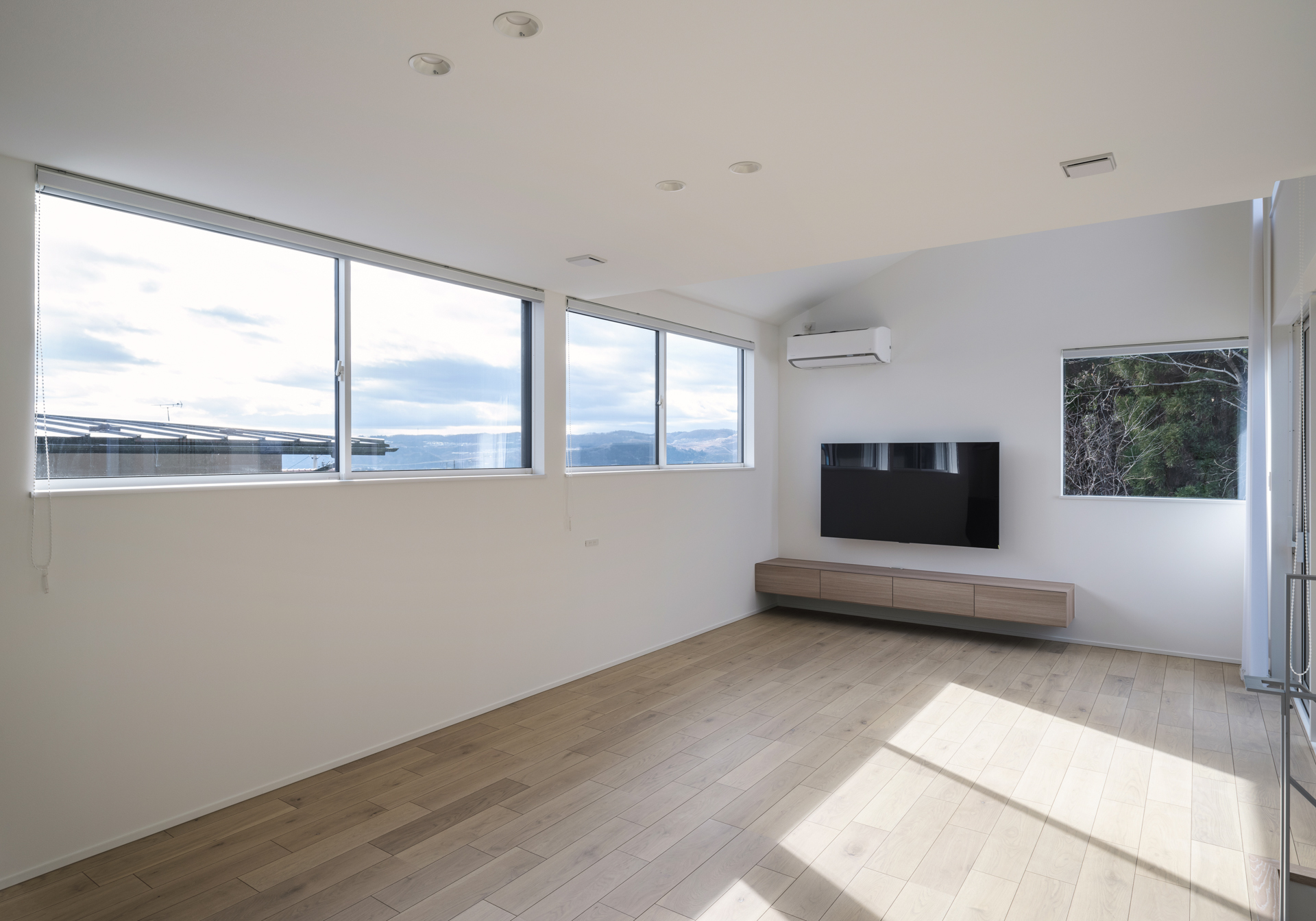 空と緑を望む住宅のリビングの窓