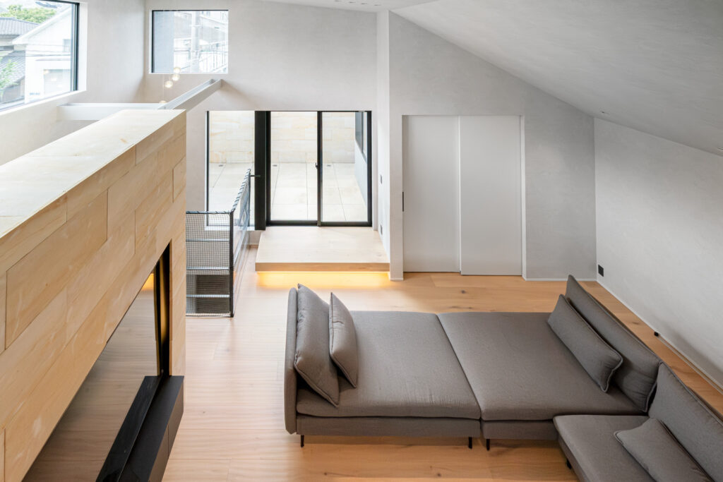 吹き抜けとハイサイドライトから自然光が入る開放的なリビング空間